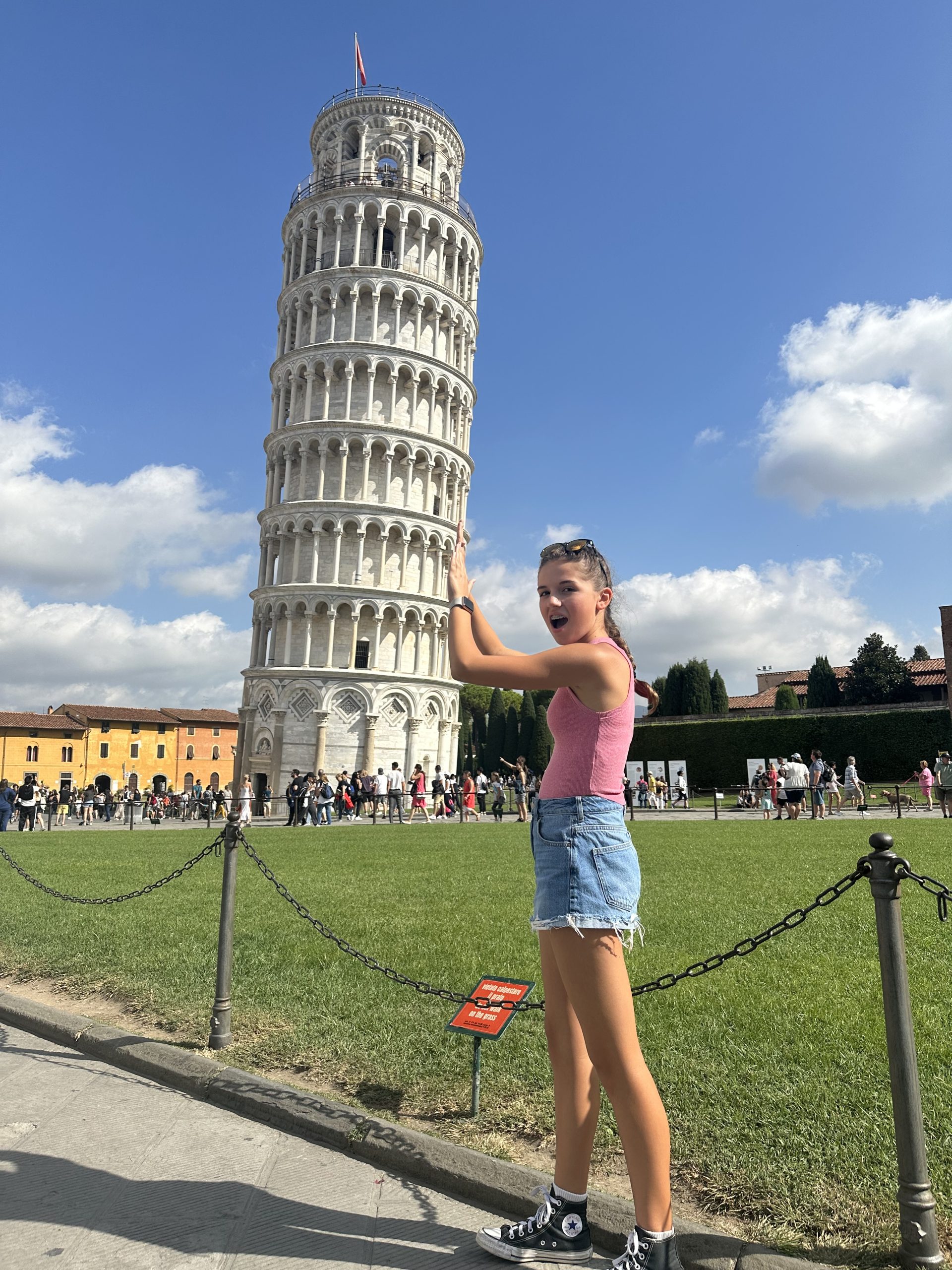 Teen child "holding up" the leaning Tower of Pisa