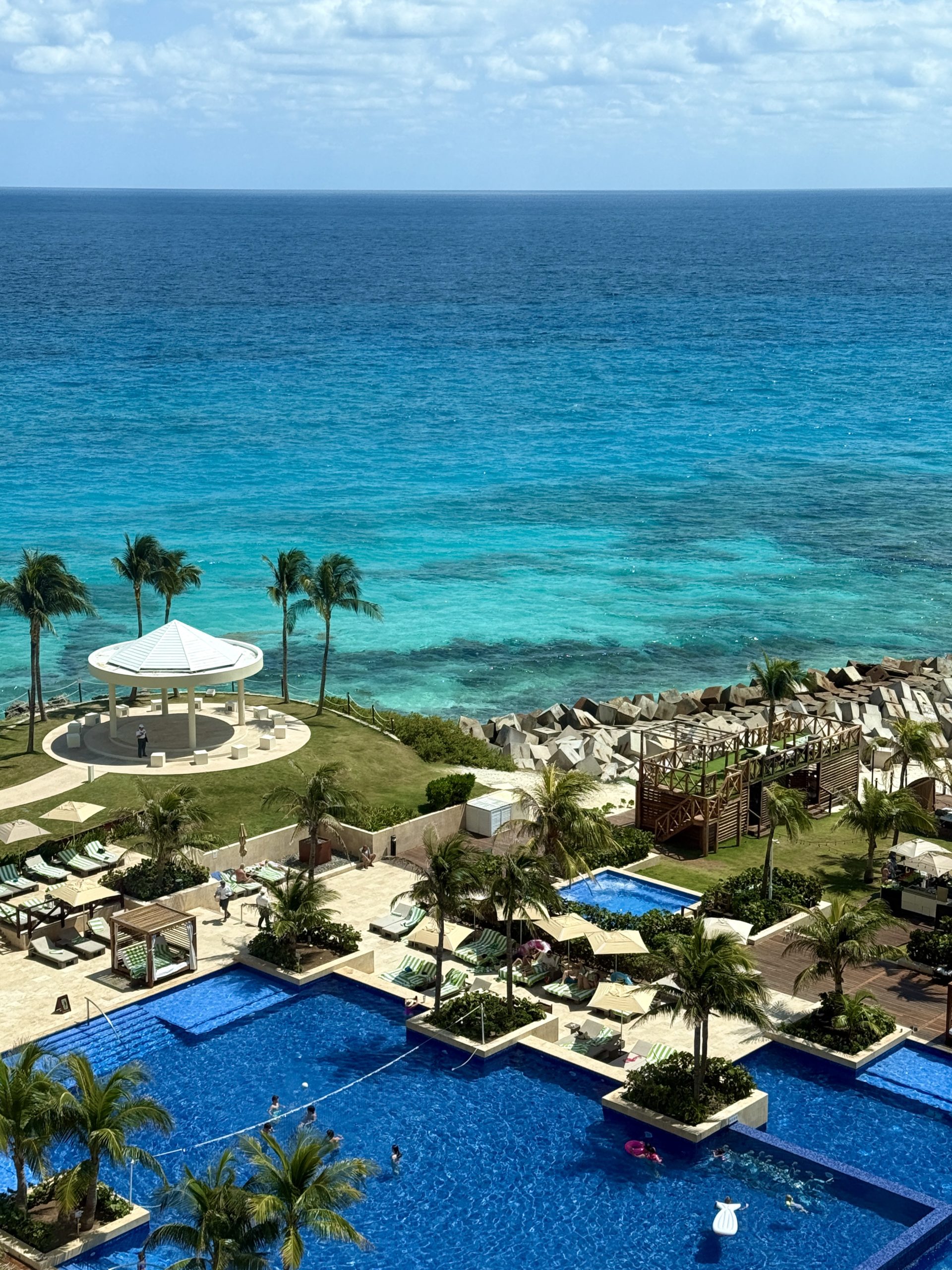 Large main pool surrounded by palm trees at Hyatt Ziva Cancun, a top family all-inclusive in the Mexican Caribbean