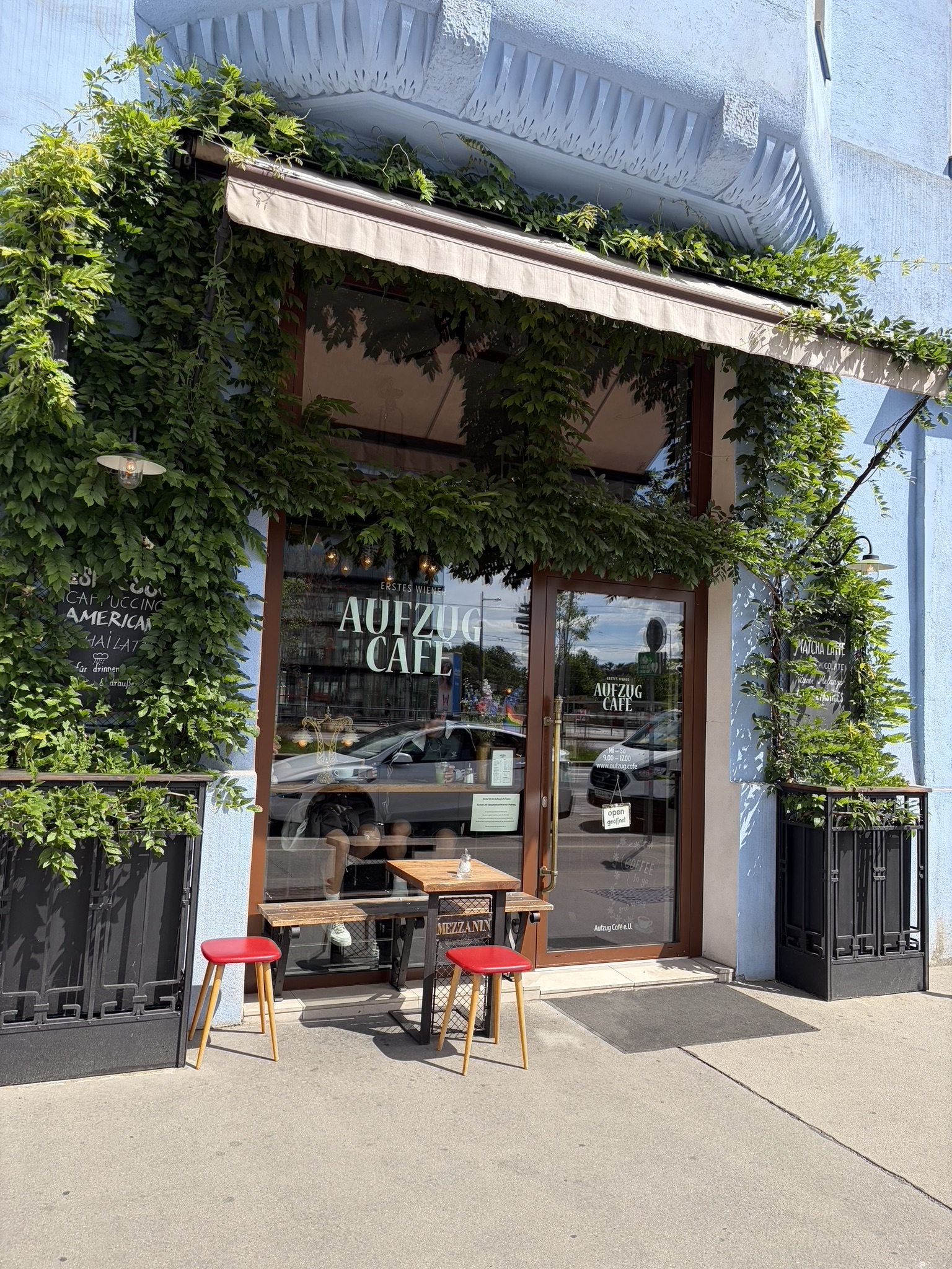 Exterior of Aufzug Café in Vienna, Austria, featuring antique elevator cars and cozy seating — a classic example of Viennese coffee house culture