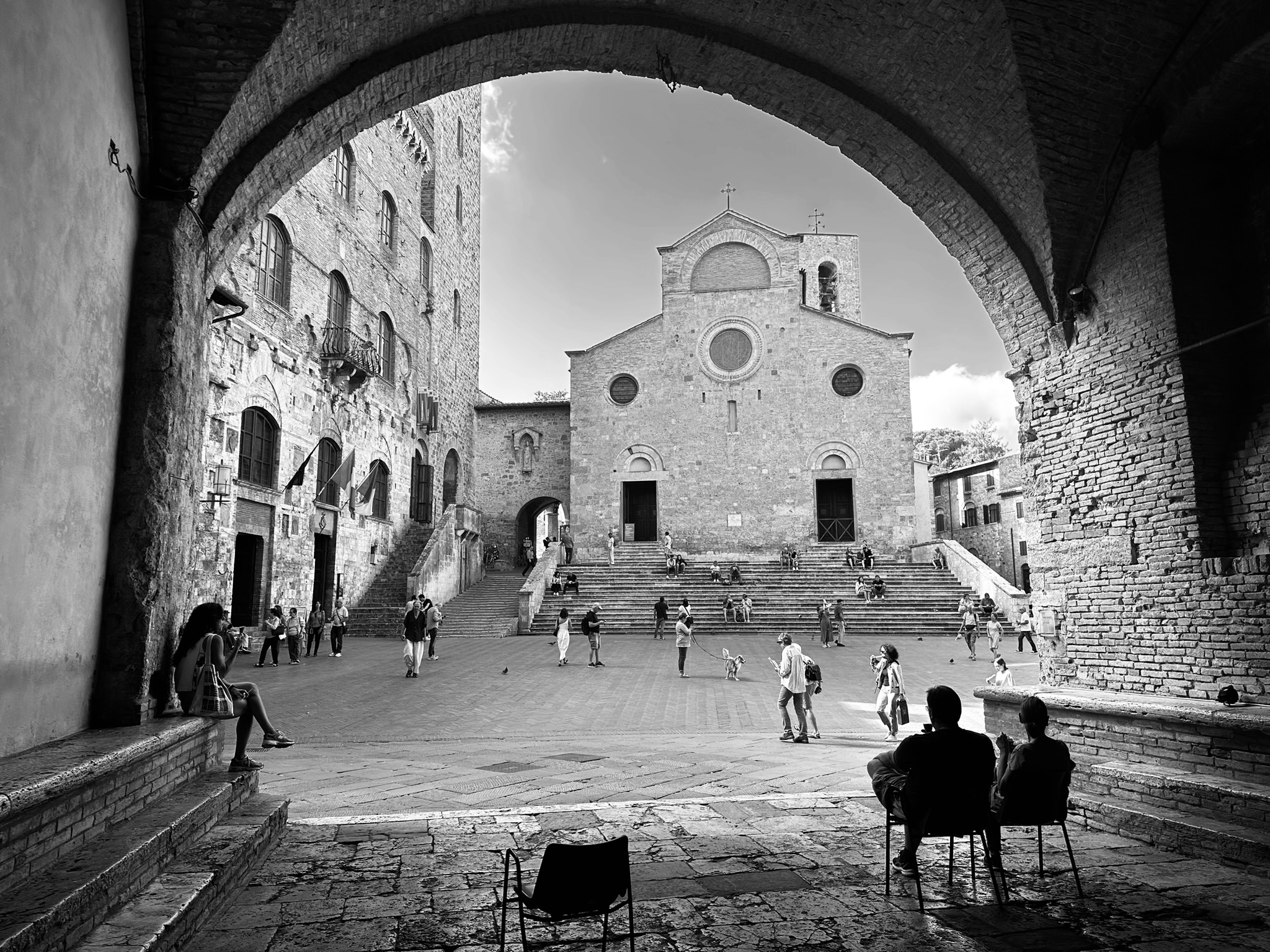 People enjoying a quiet moment in a small square in San Gimignano, Italy