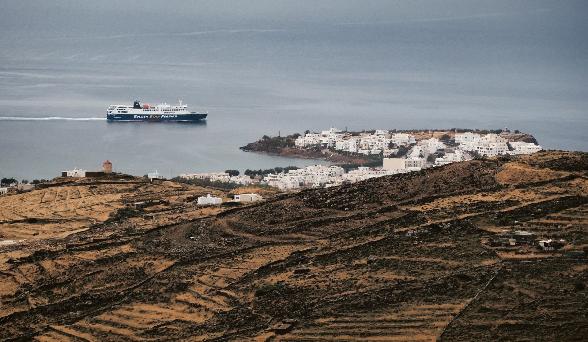 Ferry boat cruising the Aegean Sea near a picturesque Greek island village